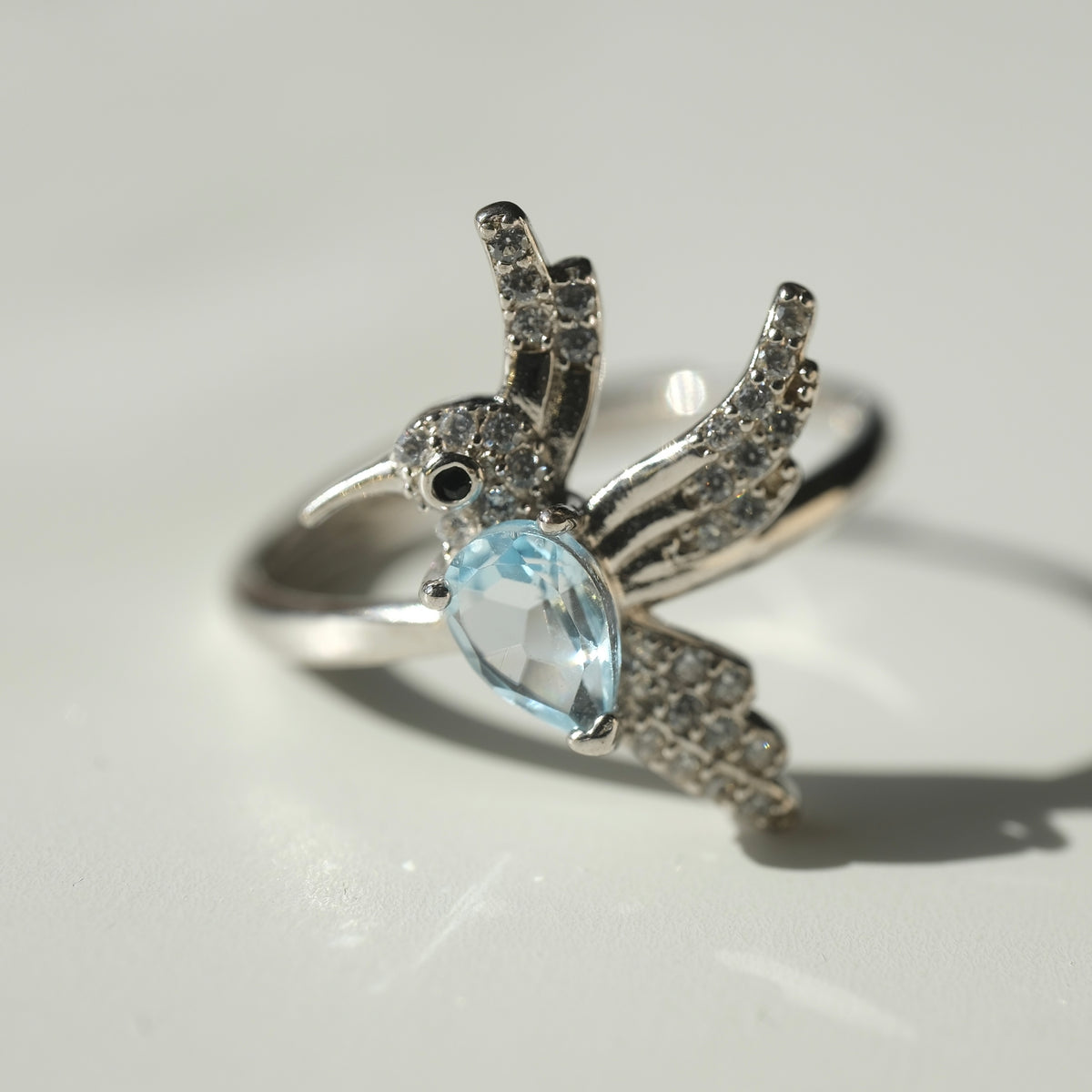 Aquamarine S925 adjustable bird ring with pale blue faceted stone and silver wings
