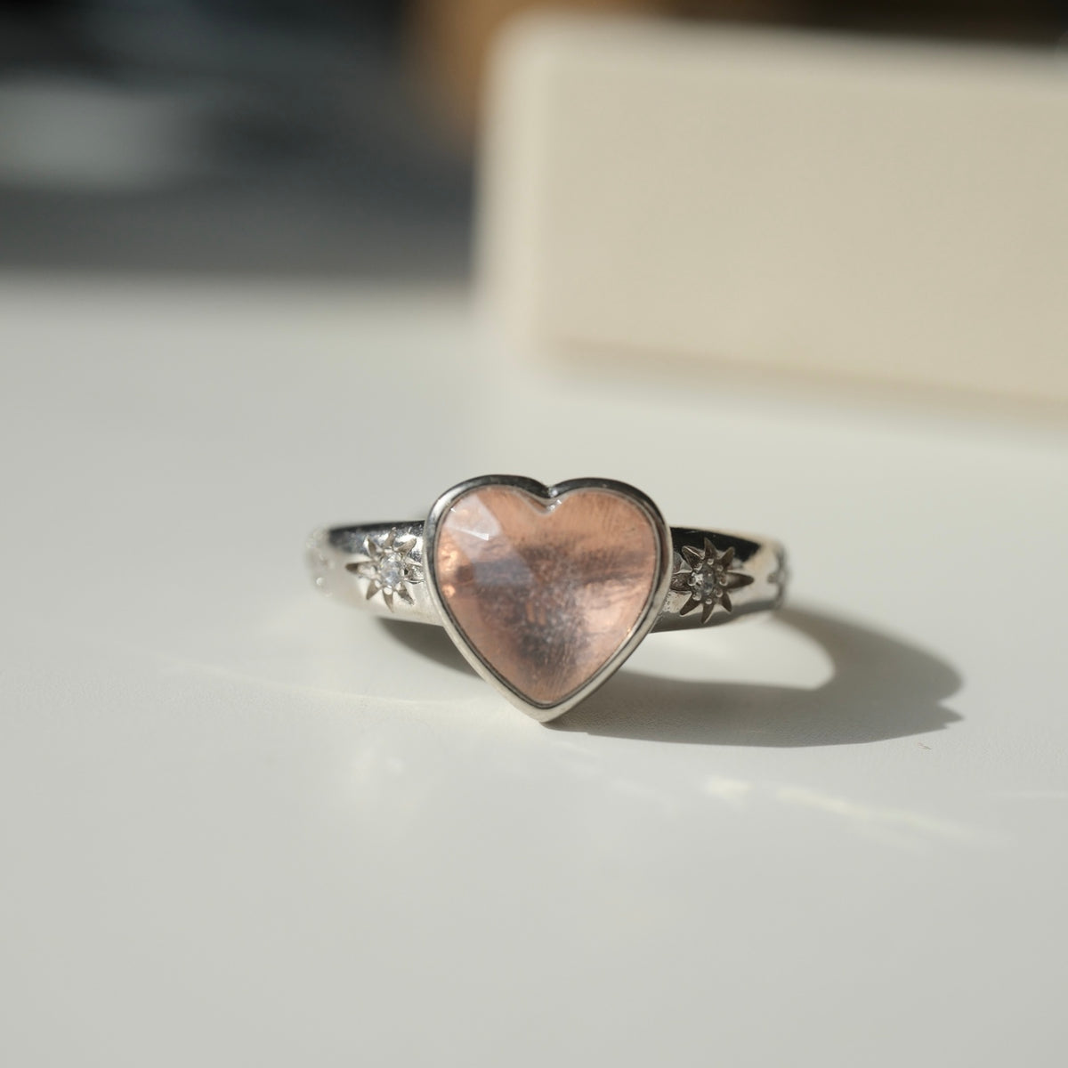 S925 heart ring with peach-coloured centre and star accents, front view