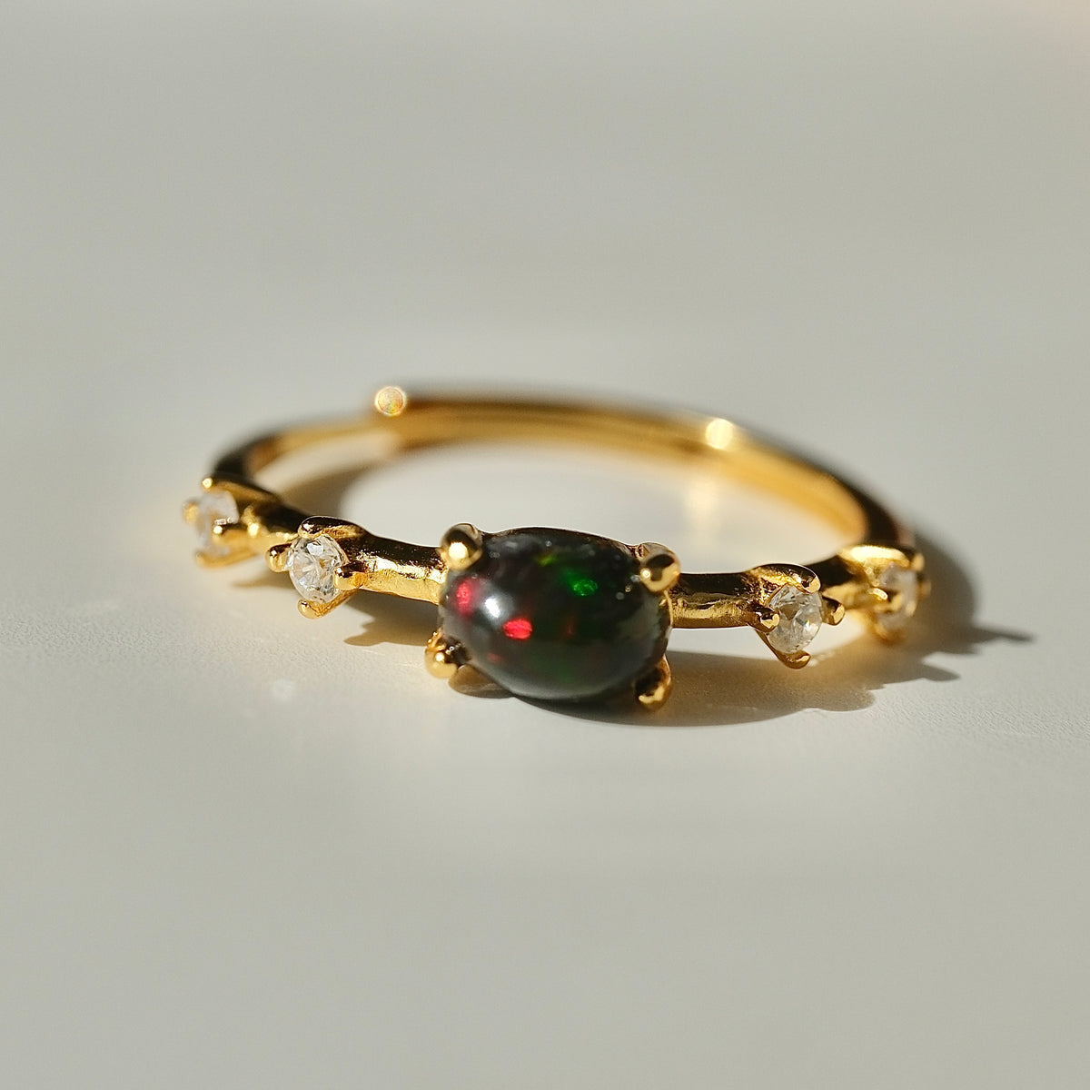 Ethiopian Black Opal adjustable ring with a gold-coloured band and clear accents