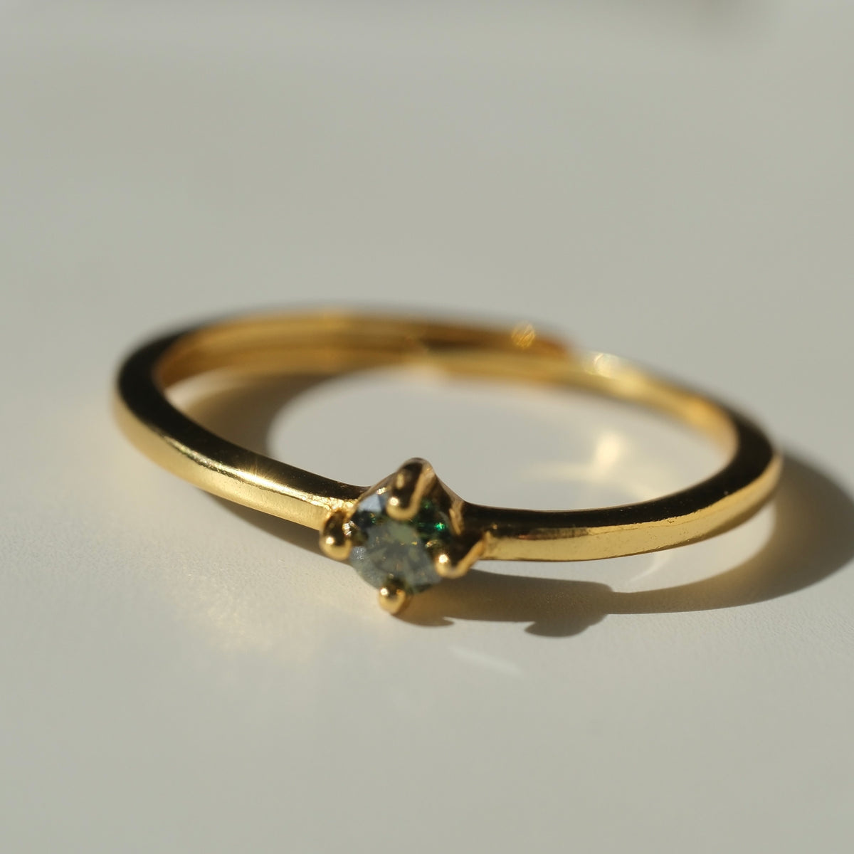 Green Moissanite ring on slim gold-tone band