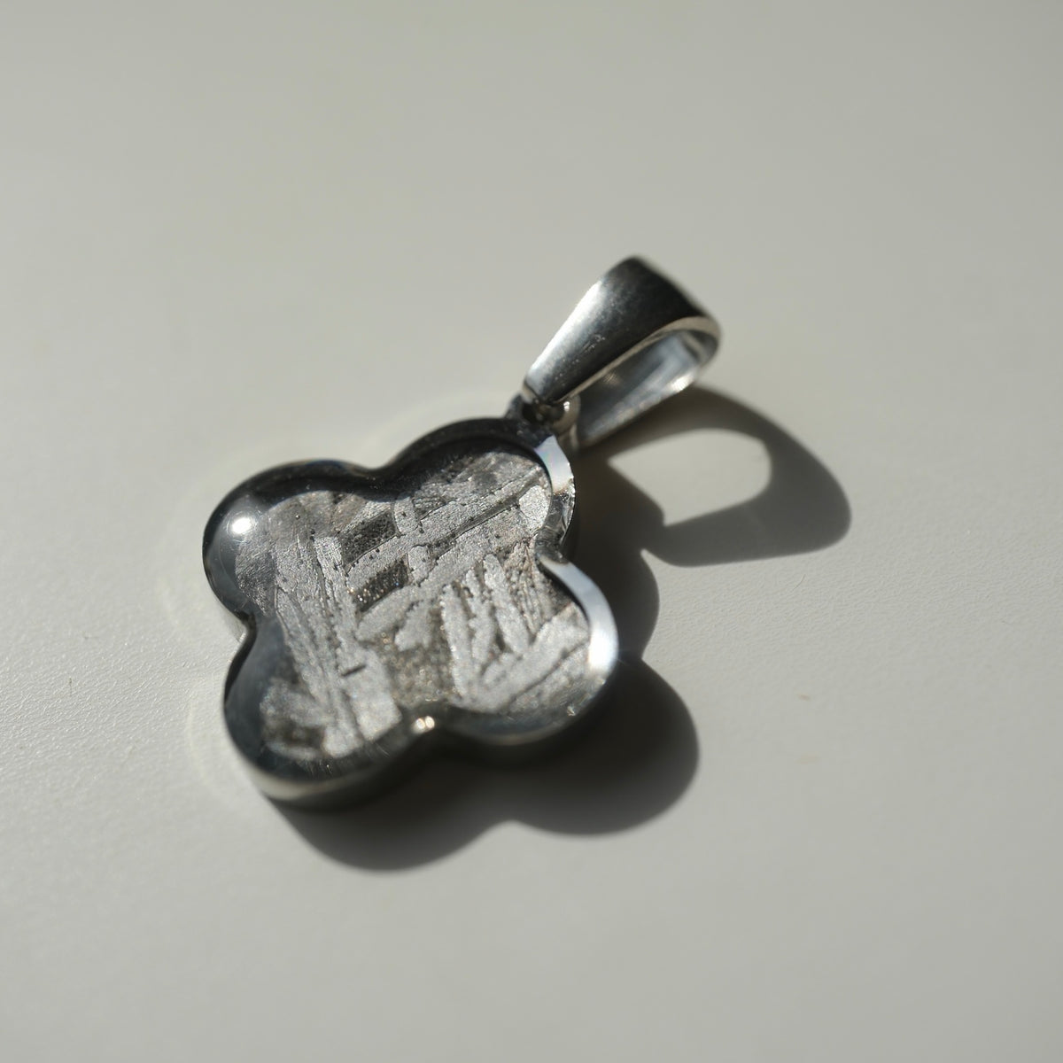 Angled view of the four-lobed Muonionalusta clover pendant