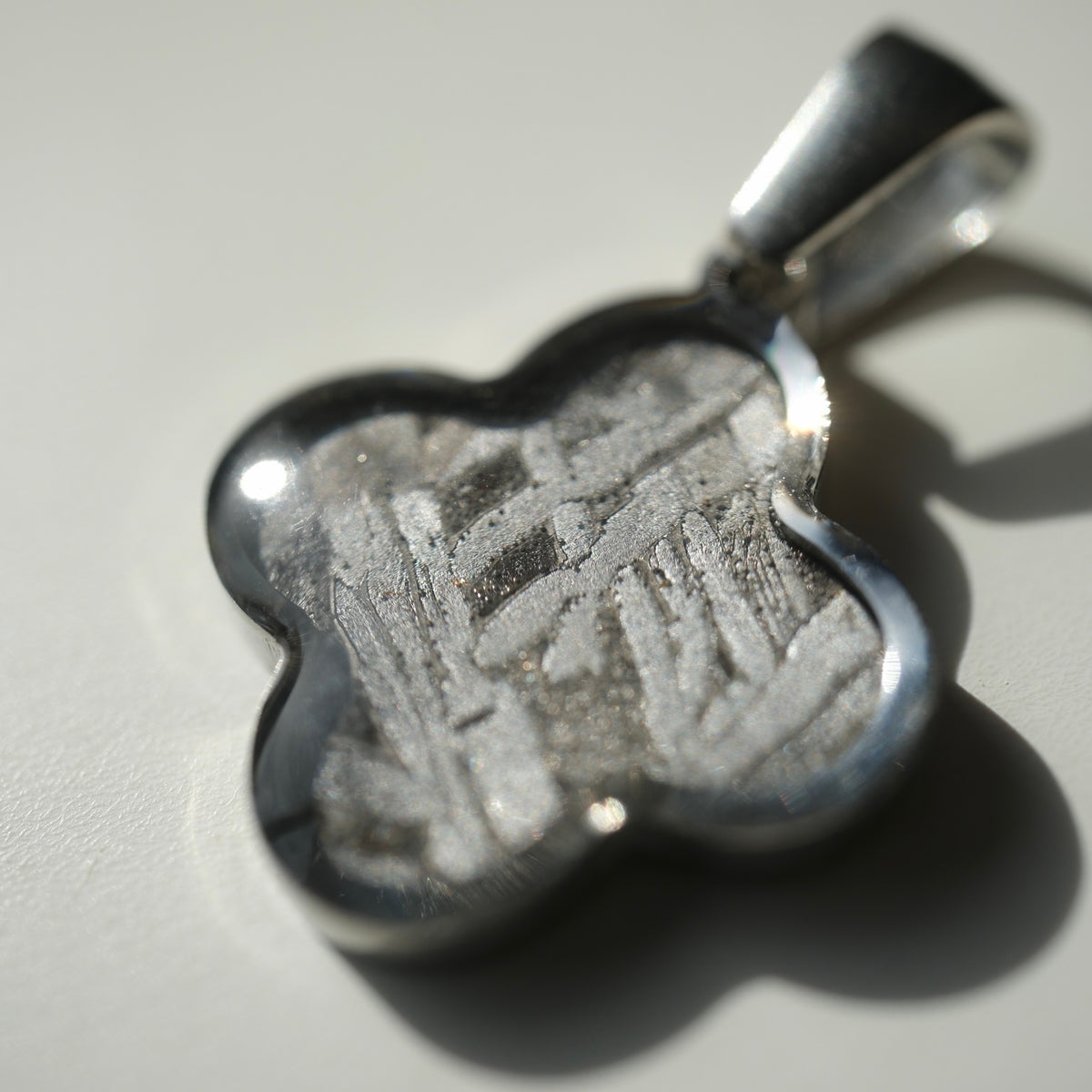 Close-up of the Muonionalusta clover pendant's metallic pattern