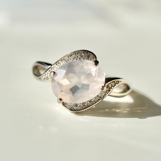 Rose Quartz S925 adjustable ring with a faceted pale pink centre stone and sweeping silver shoulders set with clear accents