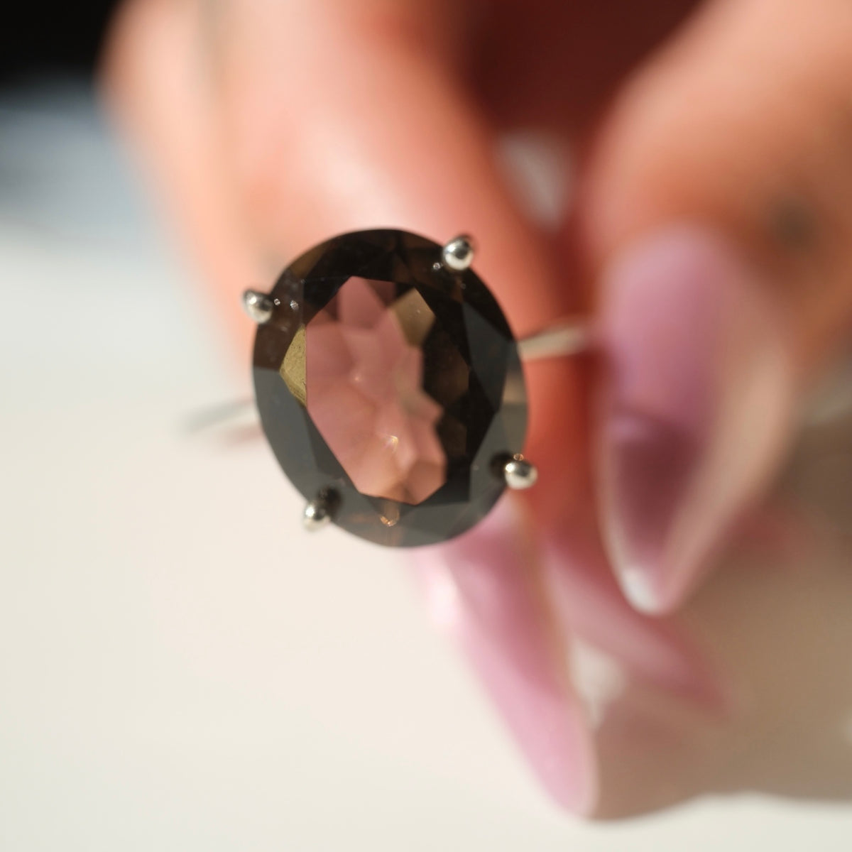 Smoky quartz ring held for scale